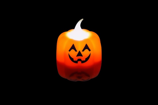 Photo halloween electric pumpkin plastic candle luminous isolated on black background