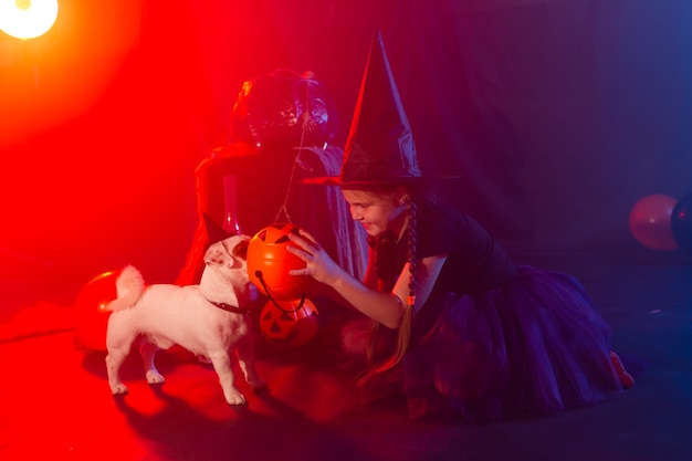 Halloween en viering concept kind meisje in heks kostuum met halloween pompoen spelen met