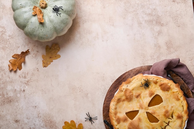 Halloween-eten Zelfgemaakte pompoentaart of taart met een eng gezicht voor Halloween op een houten tafel Kopieer ruimte Halloween-voedselconcept