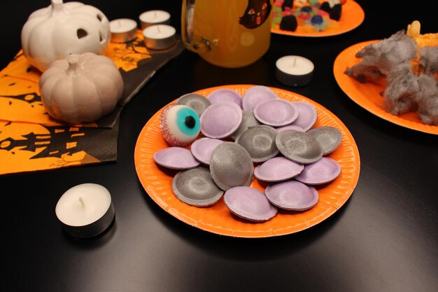 Foto halloween feest borden met snoep en snoep pot met sinaasappel frisdrank kaarsen servetten en pompoenen