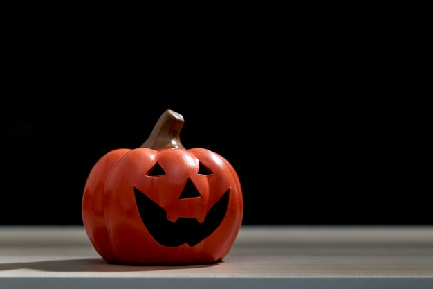 Halloween festival pumpkin Jack O lantern on wooden table in front of spooky dark background textured for banner design