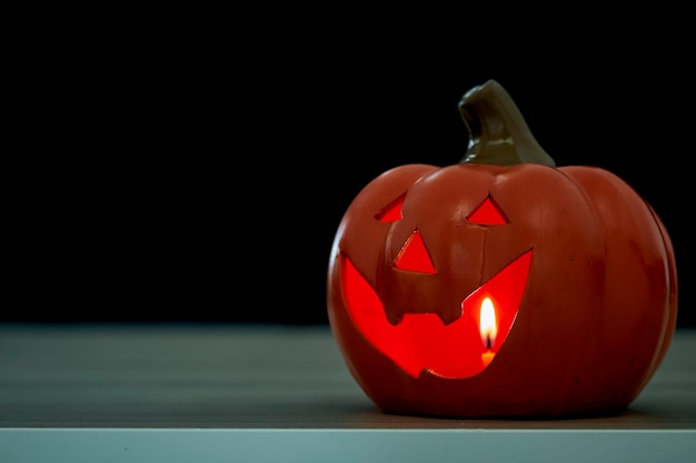 Halloween festival pumpkin Jack O lantern on wooden table in front of spooky dark background textured for banner design