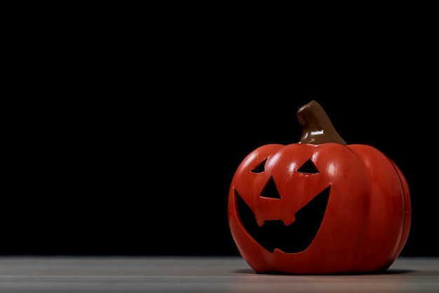 Halloween festival pumpkin Jack O lantern on wooden table in front of spooky dark background textured for banner design