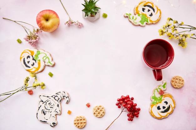 Halloween festive background red cup homemade cookies in shape of cute pumpkins and ghost