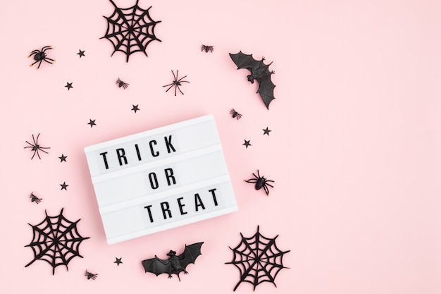 Halloween flat lay di lightbox con dolcetto o scherzetto testo e decorazione