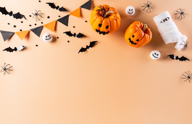 Halloween flat lay with decorations made from pumpkin, paper bats and black spider