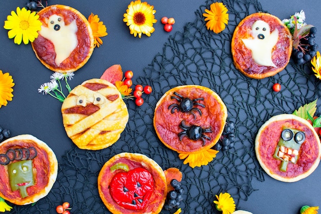 Фото Еда на хэллоуин мини-пицца с сырными оливками и кетчупом забавная безумная еда для детей