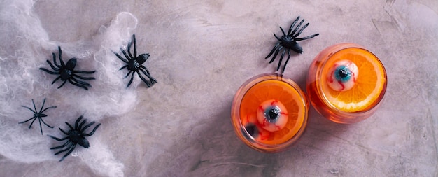 Halloween fruit bloed cocktail met ogen en oranje in glazen top view web banner