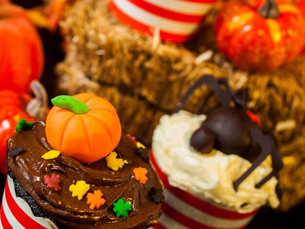Foto halloween gastronomische cupcakes met vakantie decor oranje achtergrond.