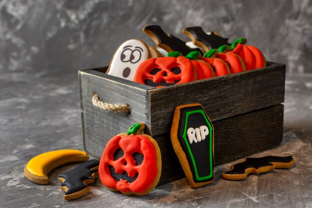 Halloween gingerbread in a wooden box on a dark stone background copy space