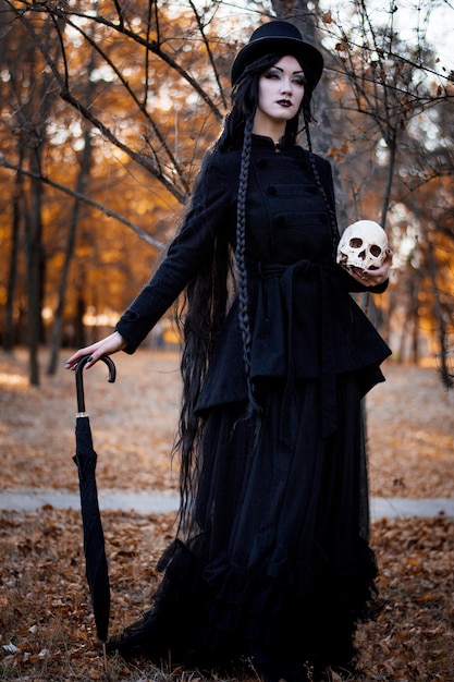 Halloween girl holding a skull over dark scary 