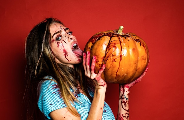 Photo halloween girl with a carved pumpkin pretty young blonde woman clothed in dress with pumpkins sexy