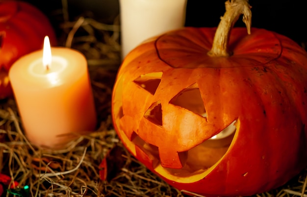 Halloween gloeiende pompoenen en kaarsen op een tafel met een rietje