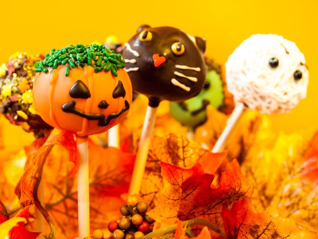 Halloween gourmet cake pops with holiday decor on orange backround