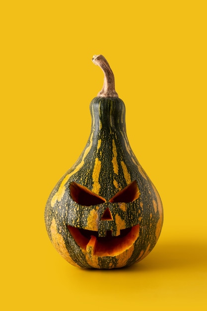 Foto zucca di halloween verde su sfondo giallo