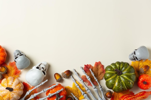 Halloween greeting card with pumpkin skulls bony hands and leaves