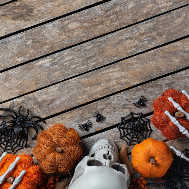 Halloween greeting card with pumpkin skulls bony hands and leaves