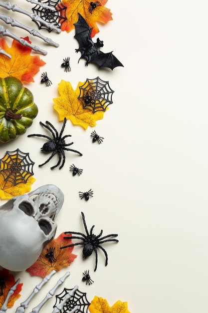 Поздравительная карточка на Хэллоуин с тыквенными черепами, костными руками и листьями.