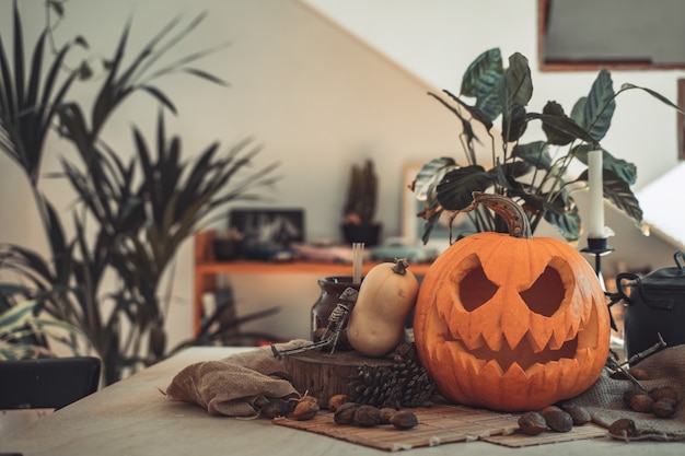 Halloween griezelig pompoengezicht in een tafel met decoratie Skeletkaarsen noten