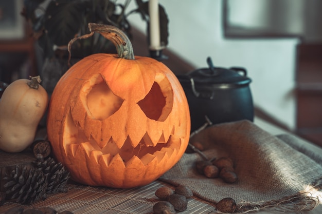 Halloween griezelig pompoengezicht in een tafel met decoratie Skeletkaarsen noten