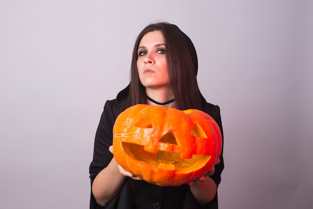 Halloween-heks met een oranje pompoen jack o lantern