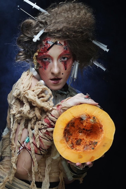 Halloween-heks met pompoen jonge vrouw met lichte make-up en creatief kapsel