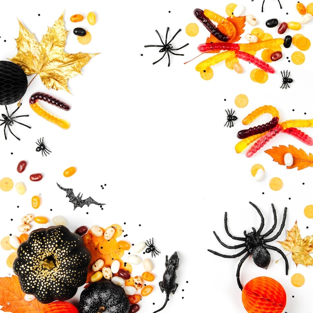 Halloween holiday background with colorful candy, bats, spiders, pumpkins and decorations. Flat lay. View from above