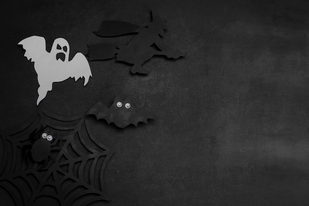 Halloween holiday. Composition with different halloween paper figures. view from above. on a dark background