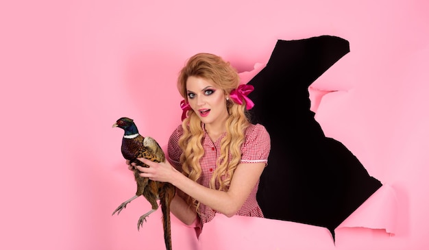 Halloween holidays and dolls Crazy girl on pink Halloween Creative idea Bird flu Funny advertising vintage woman with poultry meat retro happy woman hold pheasant So much fun Going crazy