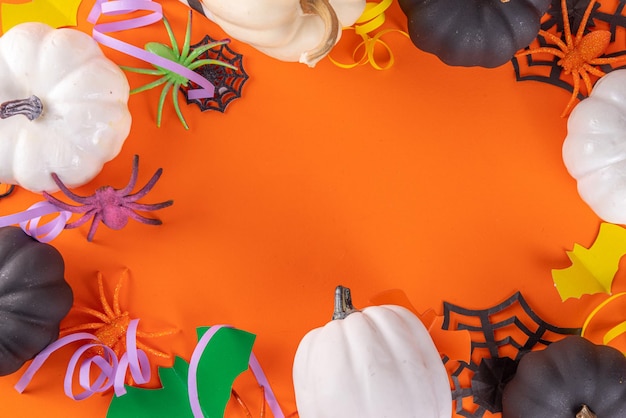 Halloween hooggekleurde gele achtergrond met kleurrijke feestvakantie accessoires en decor spinnen spinnenwebben pompoenen vleermuizen geesten bovenaanzicht plat lag kopie ruimte