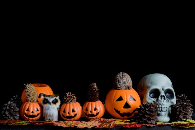 Halloween human skull, Halloween Pumpkins on an old wooden table in front of black background with free space for text. Halloween concepts. Happy Halloween Days.