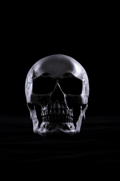 Photo halloween human skull on an old wooden table over black background shape of skull bone for death head on halloween festival which show horror evil tooth fear and scary copy space