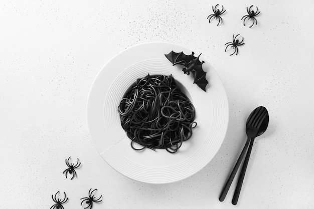 Halloween Italian black pasta decorated funny spiders in plate on white