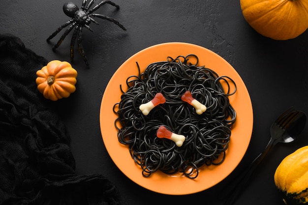 Halloween Italian black pasta decorated horror eyes in orange plate on black