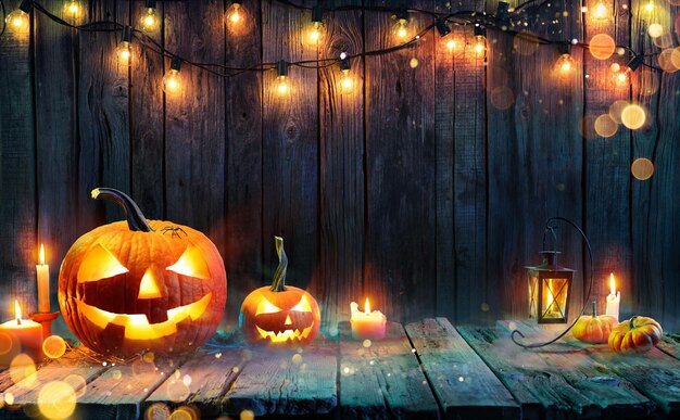 Halloween Jack O Lanterns Candles And String Lights On Wooden Table