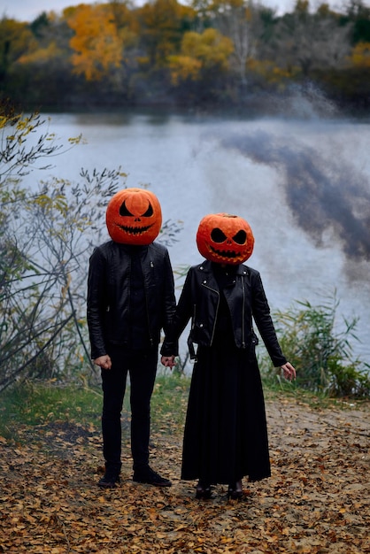 Halloween-jongen en -meisje met pompoenen op hun hoofd