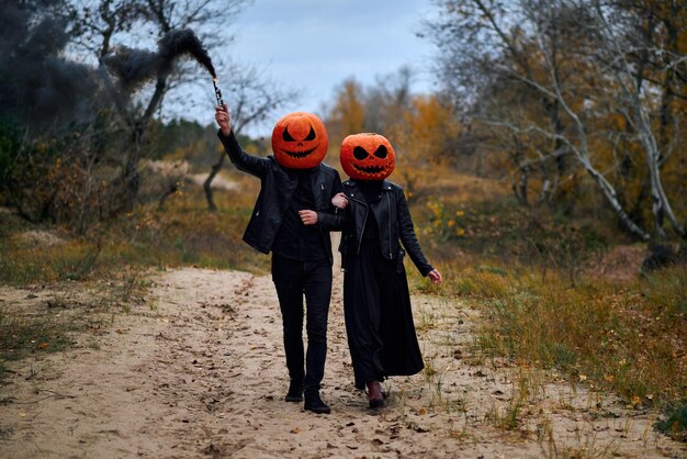 Halloween-jongen en -meisje met pompoenen op hun hoofd