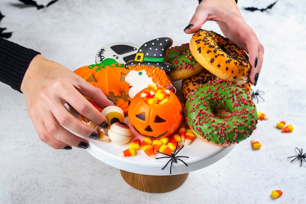 Halloween kinderfeesttafel met snoepkorrels, gemberkoekjes en griezelige donuts.