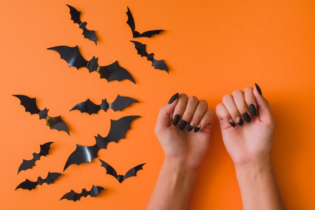 Halloween manicure hand skin care spa salon October discounts Female hands on an orange background