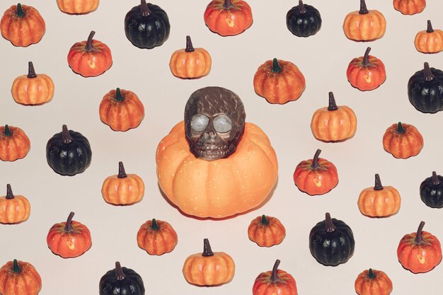 Halloween minimal concept with colorful pumpkins and brown skull Creative spooky autumn background