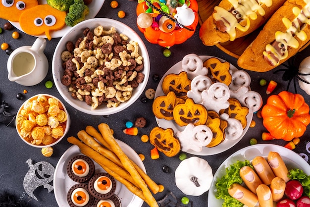 Halloween monster eten en snack assortiment Set van grappige creatieve gerechten voor kinderen Halloweenfeest kinderen brunch of ontbijtkoekjes gezonde en fastfood snacks ontbijtgranen hotdogs