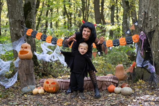 Foto la madre di halloween con il figlio piccolo in costumi di halloween che si divertono all'aperto