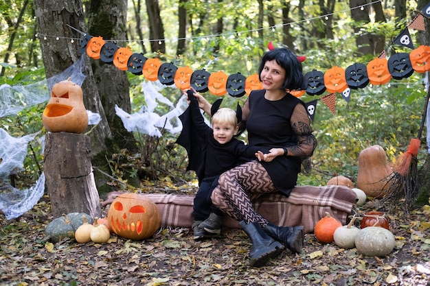 Halloween. madre con figlio piccolo in costumi di halloween divertendosi all'aperto