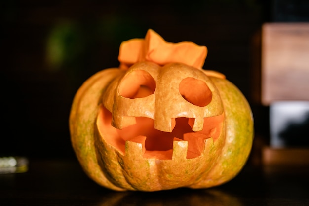 Halloween orange pumpkin with funny face on the dark background