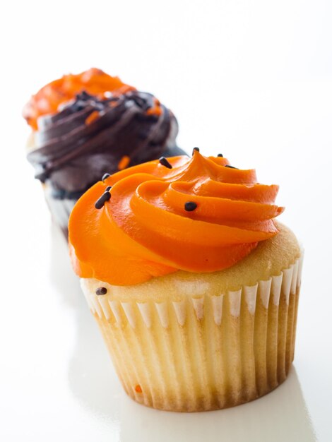 Halloween oranje en zwarte cupcakes op witte achtergrond.