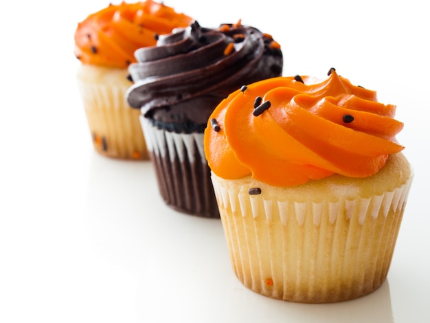 Halloween oranje en zwarte cupcakes op witte achtergrond.