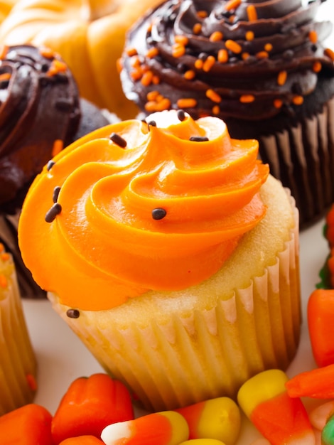 Halloween oranje en zwarte cupcakes op witte achtergrond.