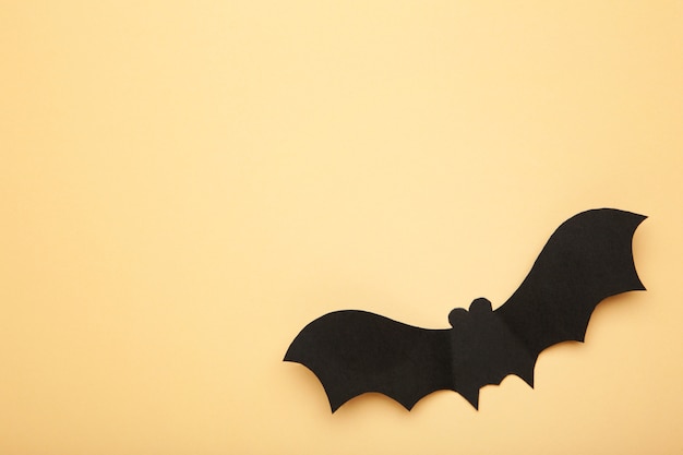 Pipistrello di carta di halloween su sfondo biege. concetto di halloween.