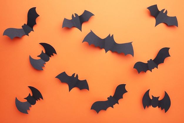 Halloween paper bats on orange background. Halloween 