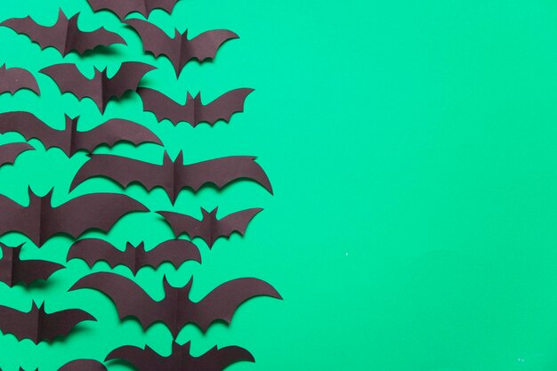 Halloween paper vampire bat decorations on a green background